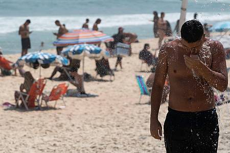 Ein Mann duscht am Strand von Ipanema. Brasilien wird derzeit von einer Hitzewelle heimgesucht.