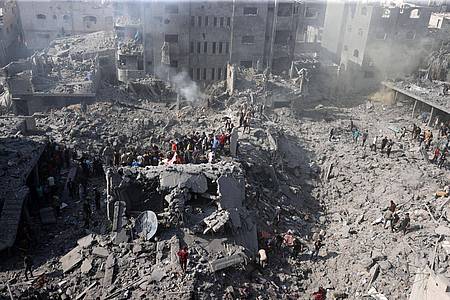 Palästinenser suchen in den Trümmern eines zerstörten Gebäudes in Bureij nach Überlebenden.