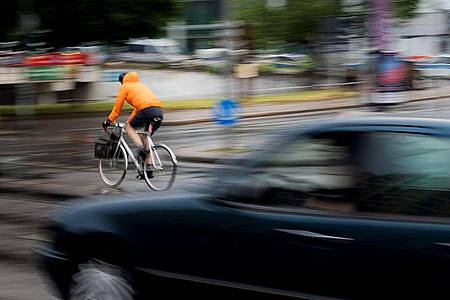 Ein Pkw fährt hinter einem Fahrradfahrer an einer Kreuzung einer Hauptverkehrsstraße in Berlin. Inwieweit Maßnahmen zur Verbesserung der Verkehrssicherheit befürwortet werden, hängt auch stark vom Alter ab.