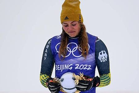 Skicrosserin Daniela Maier kämpft während der Flower Ceremony nach ihrem Bronze-Erfolg mit den Tränen. Foto: Angelika Warmuth/dpa