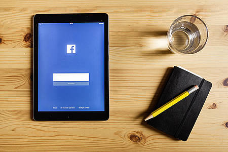 Tablet mit Facebook-App liegt auf einem Tisch
