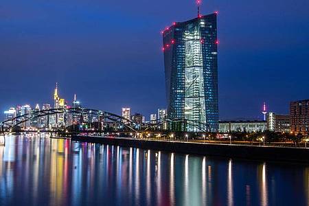 Die Lichter der Frankfurter Bankenskyline und der Europäischen Zentralbank (EZB) spiegeln sich im Main. Foto: Boris Roessler/dpa