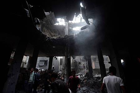 Palästinenser suchen in den Überresten eines zerstörten Gebäudes nach einem israelischen Luftangriff nach Überlebenden.