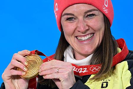 Biathletin Denise Herrmann zeigt stolz ihre Goldmedaille.