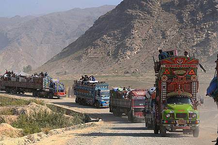 Lastwagen, auf denen afghanischen Familien sitzen, auf dem Weg zum Grenzübergang Torkham.