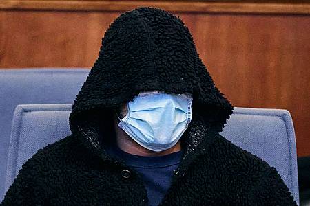 Der Angeklagte verbirgt sein Gesicht im Dortmunder Landgericht unter einer Kapuze und einer medizinischen Maske.