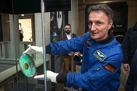 Der Astronaut Matthias Maurer platziert die Nachbildung der Himmelsscheibe von Nebra in einer Vitrine im Landesmuseum für Vorgeschichte Halle.