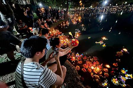 Thailänder beten an einem See im Lumphini Park, einem der größten Parks Bangkoks, bevor sie ihren Krathong ins Wasser setzen.