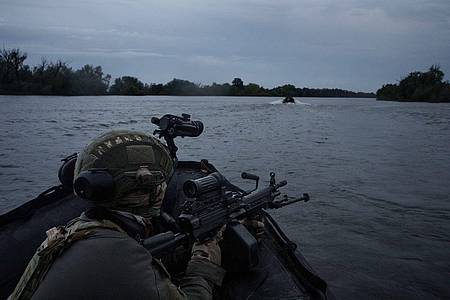 Ukrainische Soldaten fahren mit einem Boot auf dem Fluss Dnipro an der Frontlinie in der Nähe von Cherson.